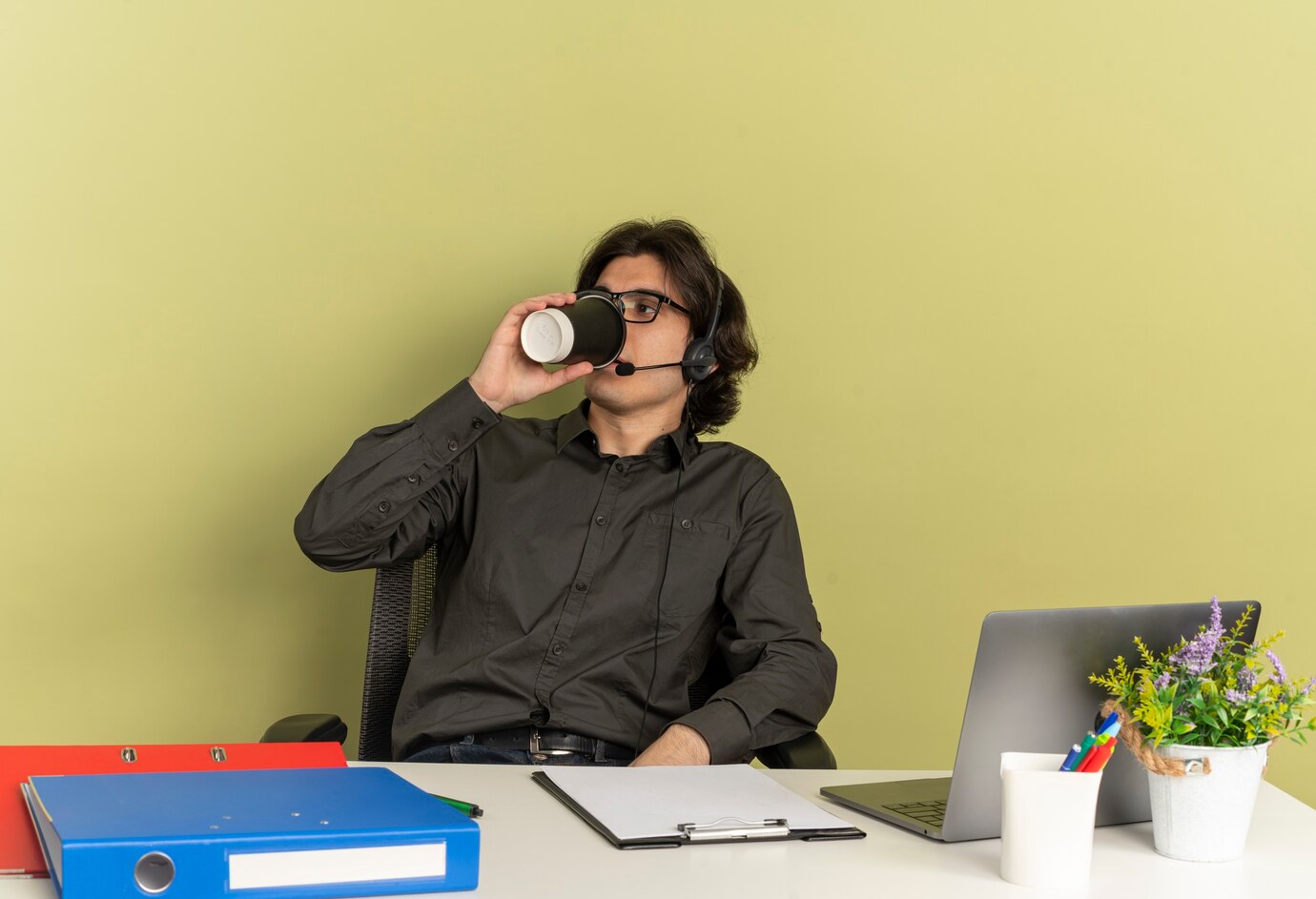 young-confident-office-worker-man-headphones-optical-glasses-sits-desk-with-office-tools-using-laptop-drinks-coffee-from-cup_141793-36991.jpg